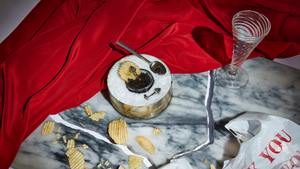 Silver cufflinks in a cup of caviar on a broken marble background